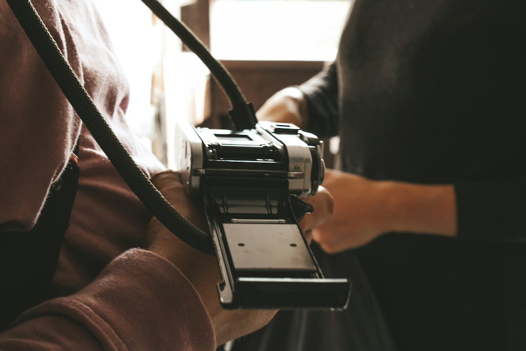 Two photographers reviewing printed photographs together on a table